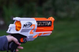 A close-up of a Nerf Ultra blaster being held outdoors, highlighting safe handling and grip techniques. This image is ideal for illustrating step-by-step tips for safe Nerf war gameplay. - Brainy Actz Escape Rooms A close-up of a Nerf Ultra blaster being held outdoors, highlighting safe handling and grip techniques. This image is ideal for illustrating step-by-step tips for safe Nerf war gameplay.