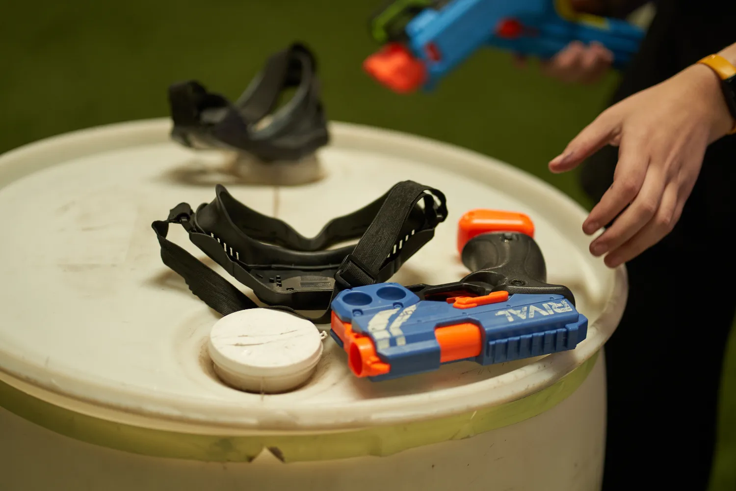 Protective goggles and a Nerf Rival gun placed on a table, emphasizing safety gear essentials for enjoyable and injury-free Nerf play.