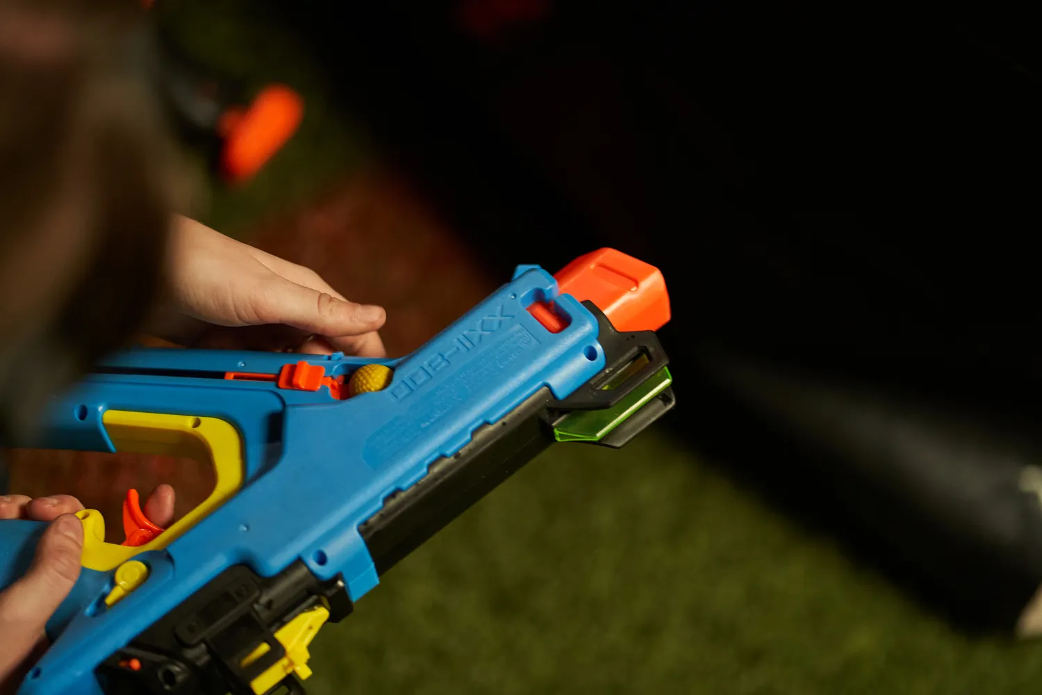 Player energetically advancing with a Nerf blaster in an indoor arena, illustrating aggressive play tactics.