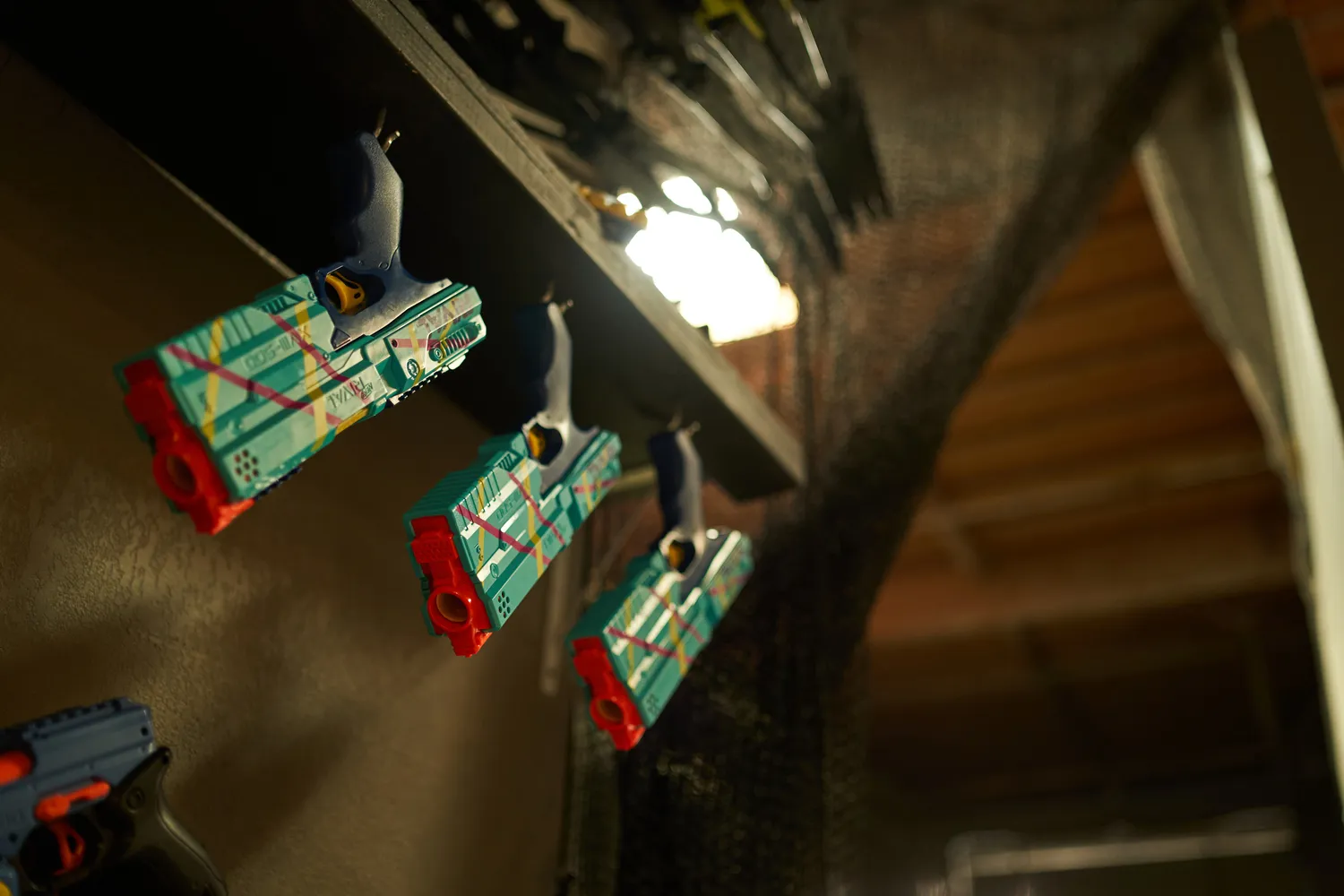 A row of colorful Nerf guns hanging on a wall, ready for action.
