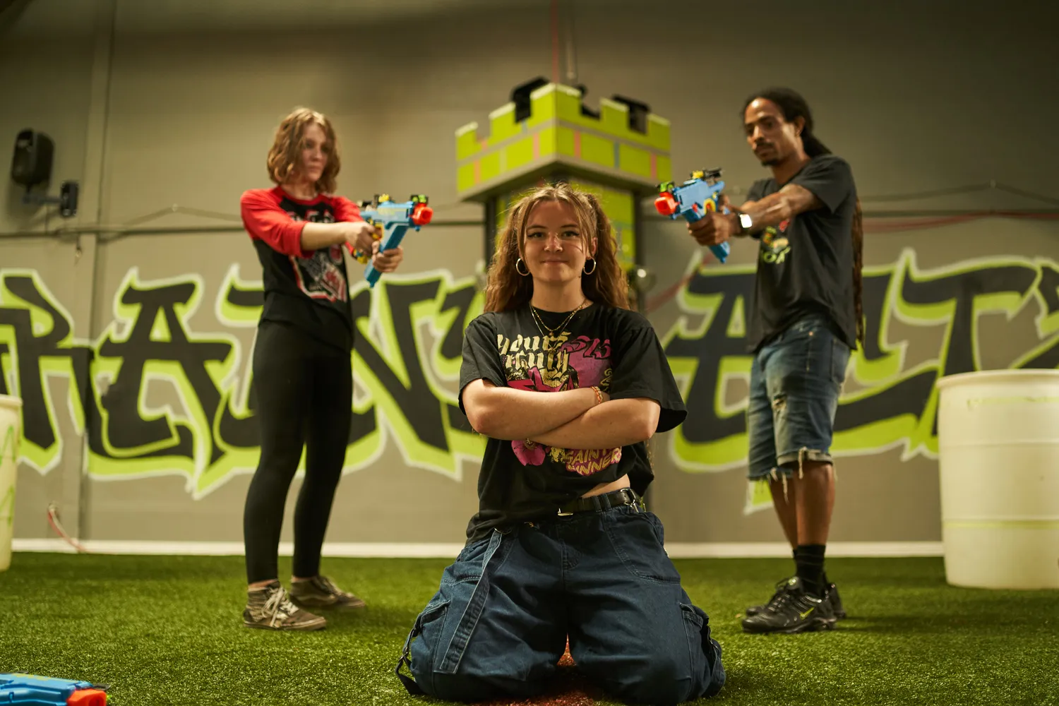 A group of Nerf war participants posing with their blasters, ready for action, setting up the battlefield in a brightly colored environment.