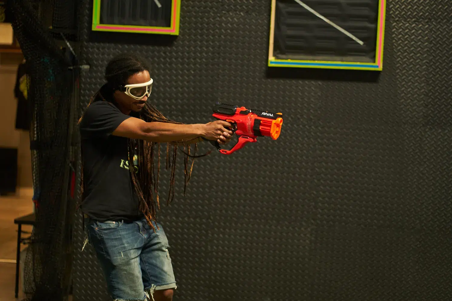 A participant aiming their Nerf blaster in the middle of a competitive battle, highlighting focus and strategy