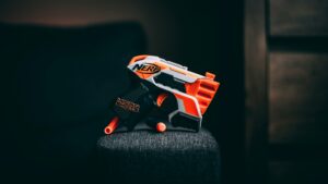 photo 1591197805022 c8e3159e88cfjpeg - Brainy Actz Escape Rooms A compact Nerf Micro Shots blaster rests on a cushioned surface, ideal for budget-friendly battle kit options.