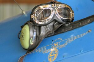 Protective goggles and earmuffs rest on a vintage aircraft, symbolizing safety and injury prevention. This highlights the key benefits of wearing protective gear during Nerf battles. - Brainy Actz Escape Rooms Protective goggles and earmuffs rest on a vintage aircraft, symbolizing safety and injury prevention. This highlights the key benefits of wearing protective gear during Nerf battles.