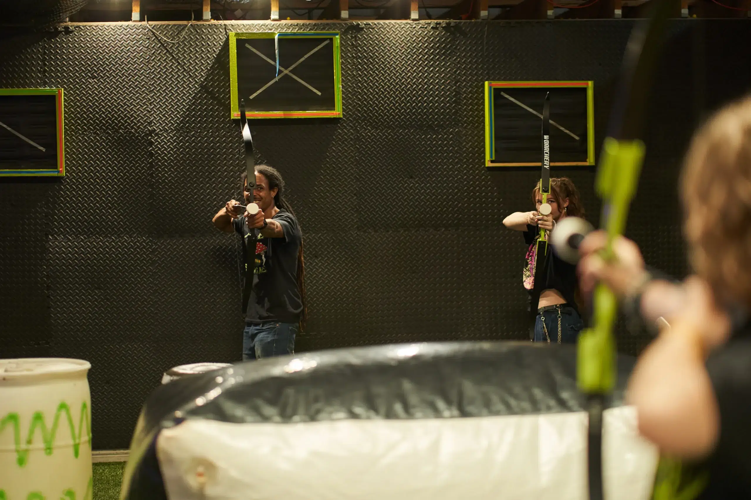 Instructors and players in an indoor arrow tag arena demonstrate proper safety practices, highlighting the importance of clear guidelines for safe gameplay. - Brainy Actz Escape Rooms Instructors and players in an indoor arrow tag arena demonstrate proper safety practices, highlighting the importance of clear guidelines for safe gameplay.