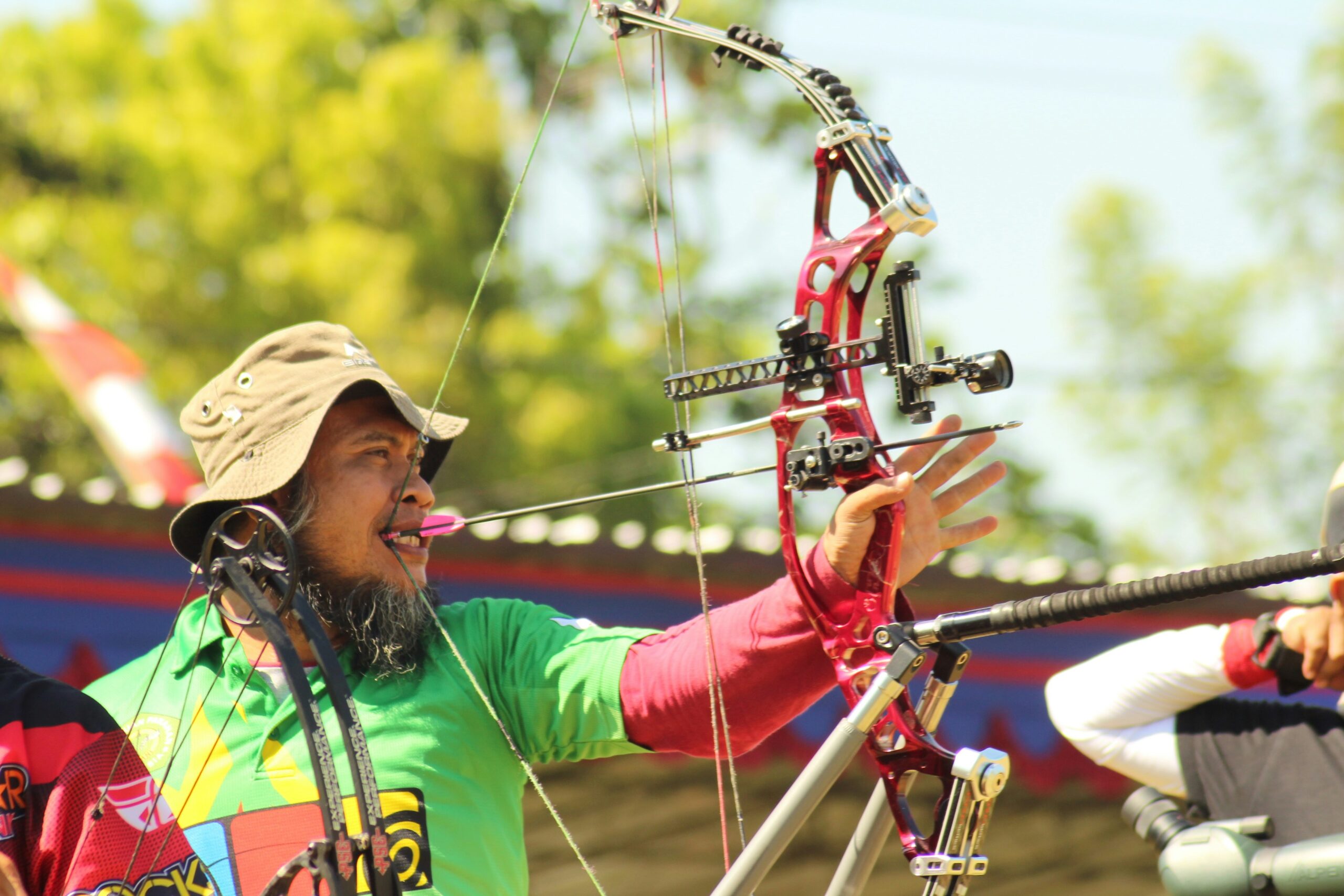 An archer prepares to release an arrow with a compound bow, demonstrating the importance of enforcing safe play directives and clear game management in archery tag.