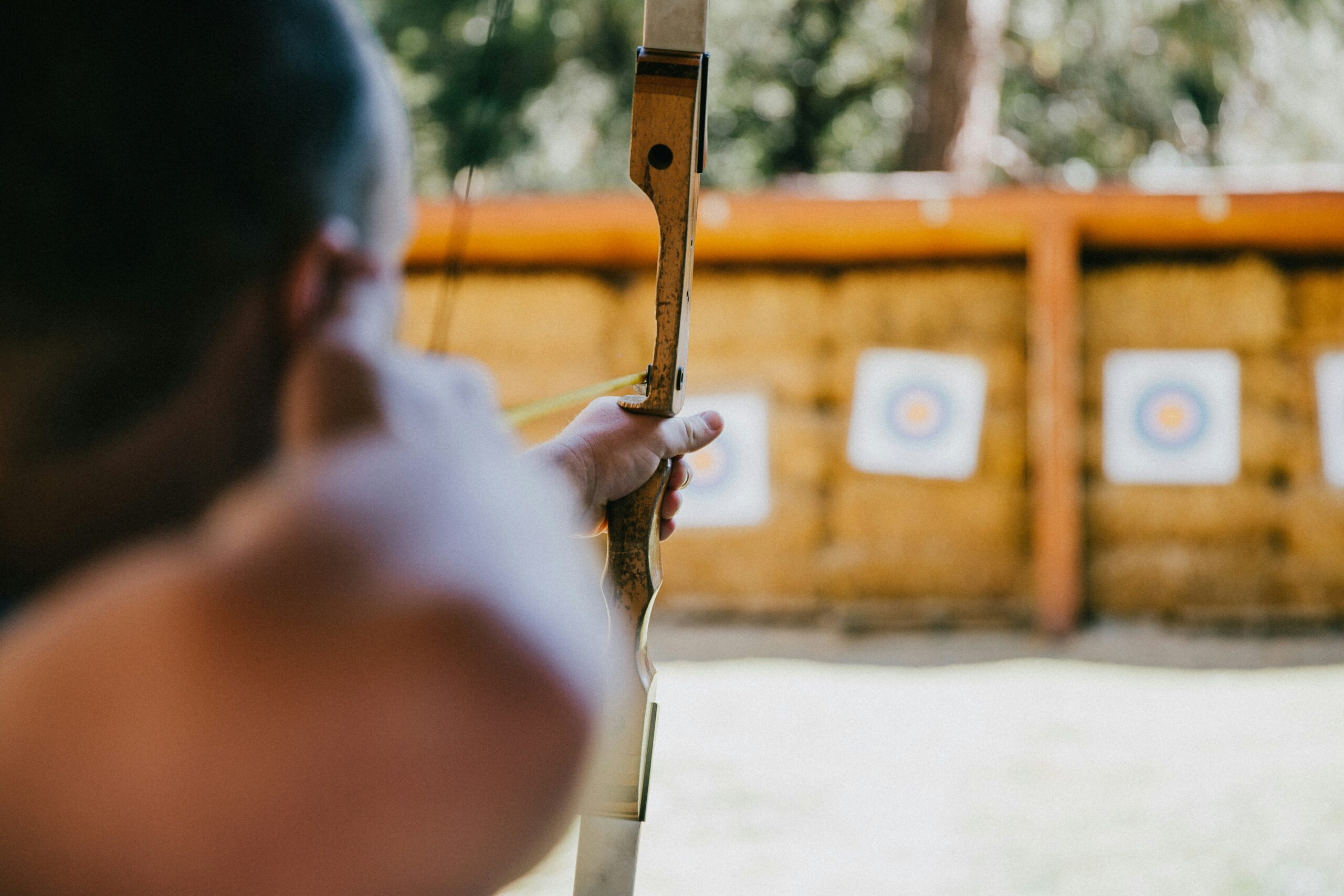 A player takes aim at multiple targets set against a straw backdrop, showcasing a safe and engaging DIY Archery Tag setup optimized for fun and protection.
