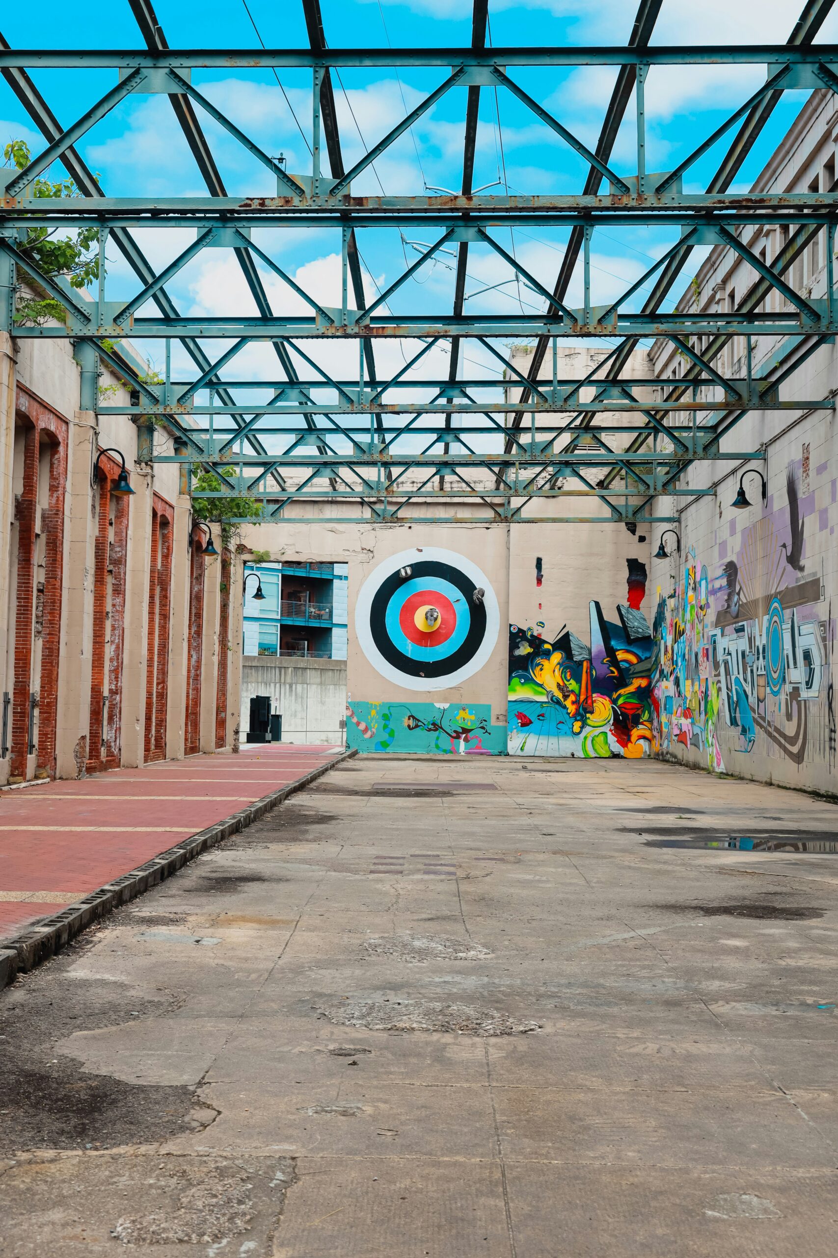 A vibrant archery range features a multicolored bullseye target on a wall, showcasing diverse target face designs ideal for varied scoring systems. - Brainy Actz Escape Rooms A vibrant archery range features a multicolored bullseye target on a wall, showcasing diverse target face designs ideal for varied scoring systems.