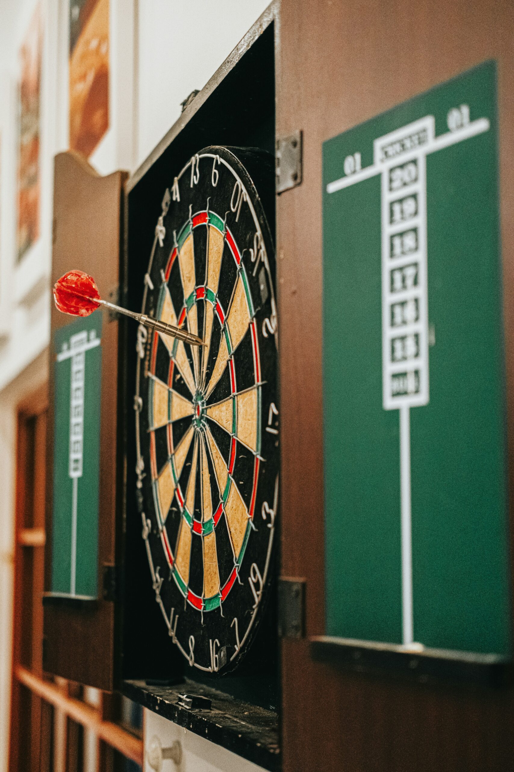 A close-up of a dartboard with a dart at the center, illustrating the importance of regular use and proper care in preserving the accuracy and durability of target systems. - Brainy Actz Escape Rooms A close-up of a dartboard with a dart at the center, illustrating the importance of regular use and proper care in preserving the accuracy and durability of target systems.