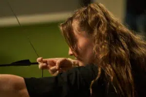 - Brainy Actz Escape Rooms A focused player aims an arrow in an Archery Arrow Tag game.