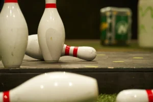 A close-up of scattered Bowlball pins on turf, representing the mental focus, precision, and concentration needed for high-scoring gameplay. - Brainy Actz Escape Rooms A close-up of scattered Bowlball pins on turf, representing the mental focus, precision, and concentration needed for high-scoring gameplay.