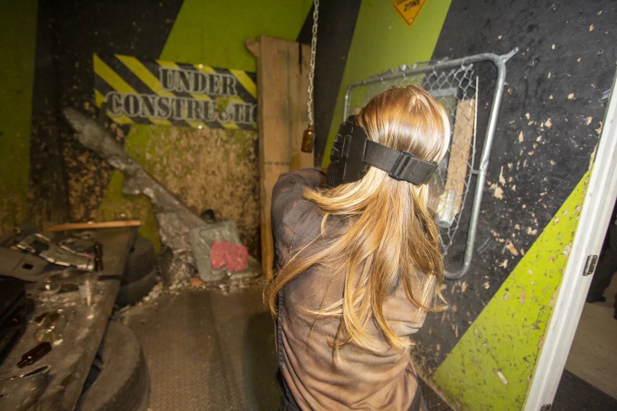 A woman mid-swing in a rage room, surrounded by broken objects—illustrating how unstructured physical release can spark fresh ideas and unlock creative energy.